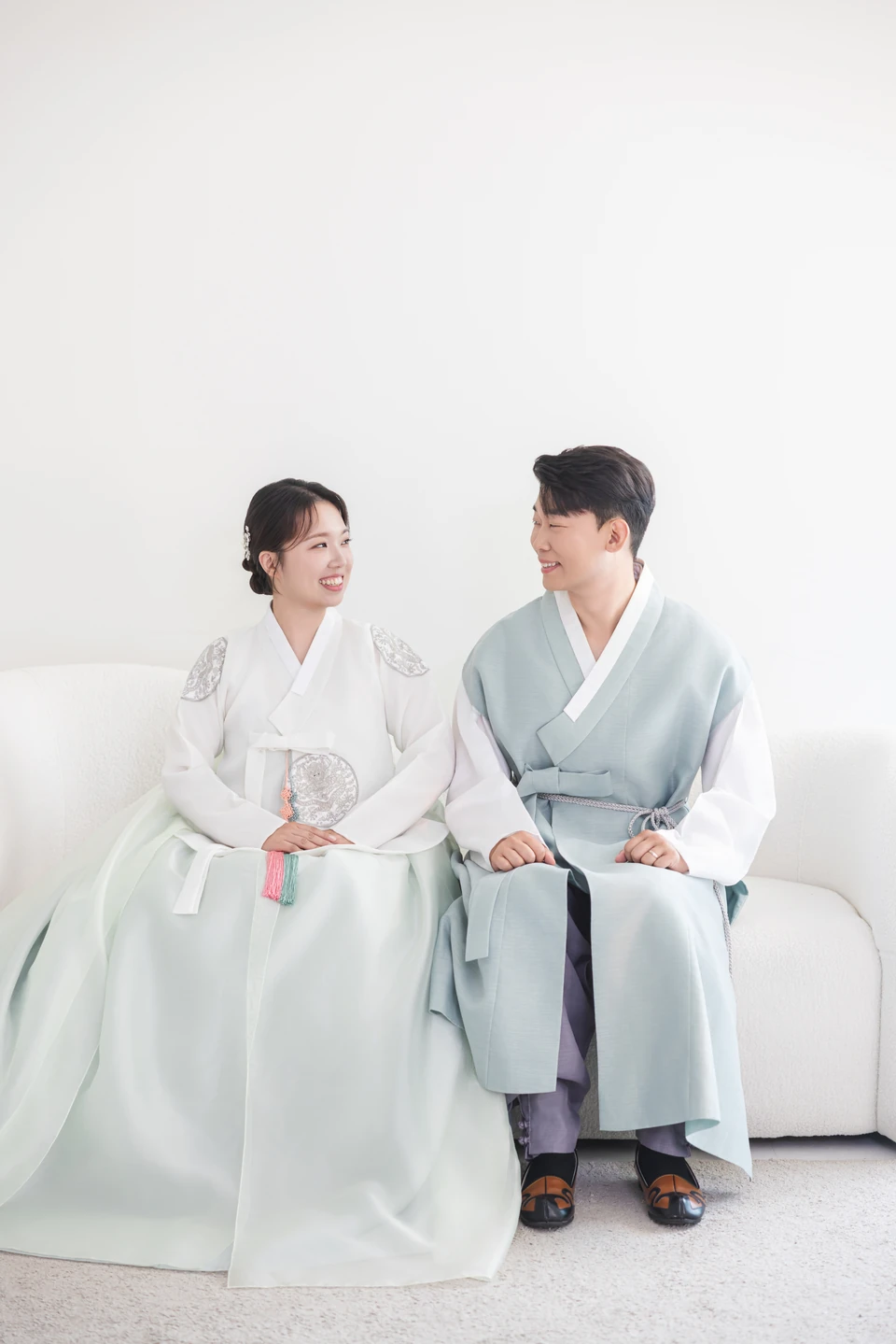 한복을 입고 마주 보며 웃는 두 사람